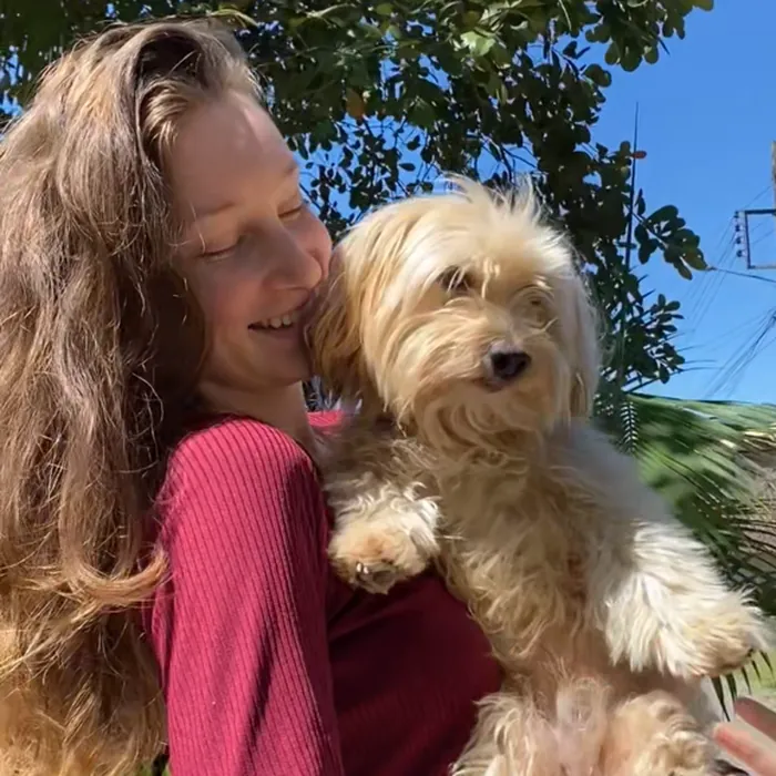 Luana abraçada com o seu cachorro